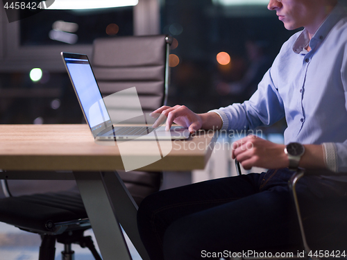 Image of man working on laptop in dark office