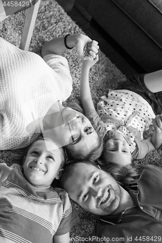 Image of happy family lying on the floor