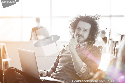 Image of Young businessman using computer at work