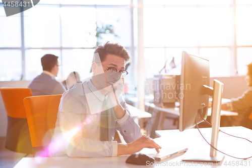 Image of Young businessman using computer at work