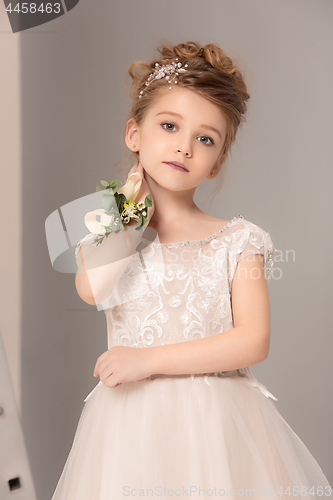 Image of Little pretty girl with flowers dressed in wedding dresses