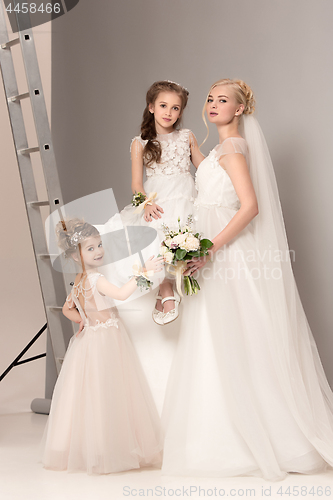 Image of Little pretty girls with flowers dressed in wedding dresses