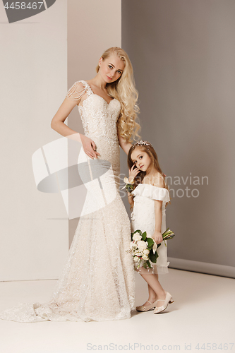 Image of Little pretty girls with flowers dressed in wedding dresses