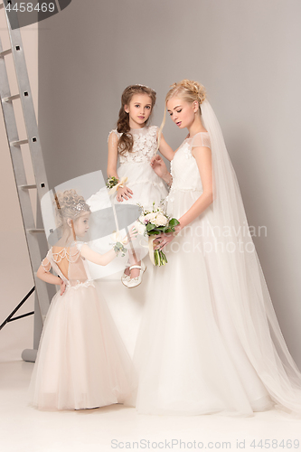 Image of Little pretty girls with flowers dressed in wedding dresses