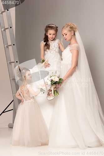 Image of Little pretty girls with flowers dressed in wedding dresses