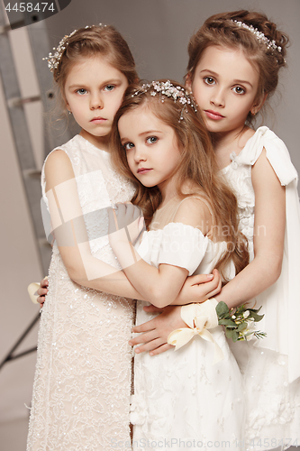 Image of Little pretty girls with flowers dressed in wedding dresses