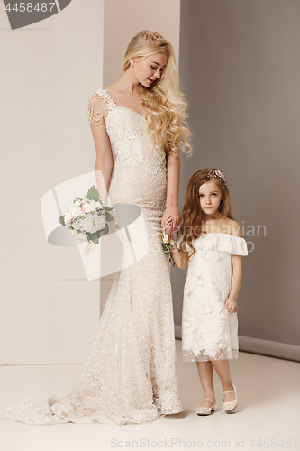 Image of Little pretty girls with flowers dressed in wedding dresses