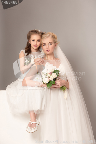 Image of Little pretty girls with flowers dressed in wedding dresses