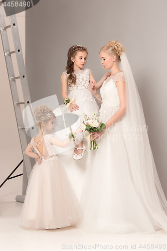 Image of Little pretty girls with flowers dressed in wedding dresses