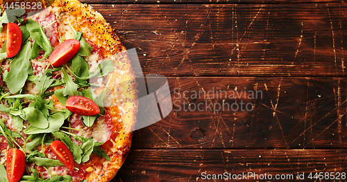 Image of Delicious italian pizza served on wooden table