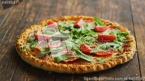 Image of Delicious italian pizza served on wooden table