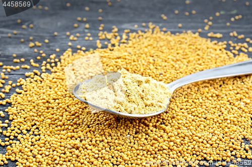 Image of Mustard powder in spoon on black board