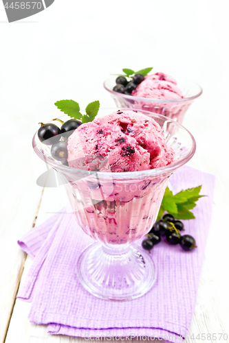 Image of Ice cream with black currant in two glasses on light board