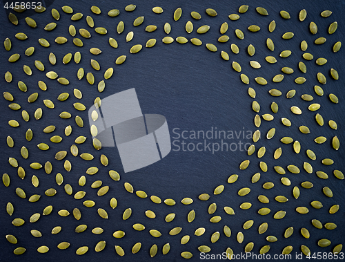 Image of Pumpkin seeds frame on black slate background