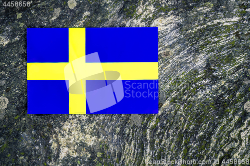 Image of Swedish flag on mossy rock background