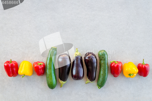 Image of Row of colorful summer vegetables on concrete background