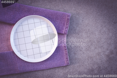 Image of Checked white plate and purple tablecloth