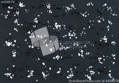 Image of Flake sea salt and black pepper on dark background