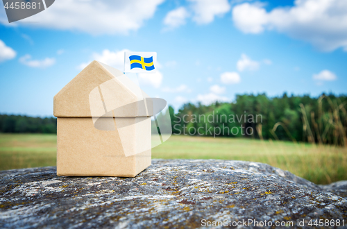 Image of Little cardboard house with a Swedish flag