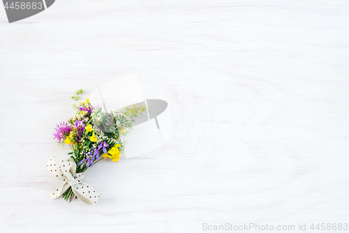 Image of Bouquet of wild flowers on white wooden background