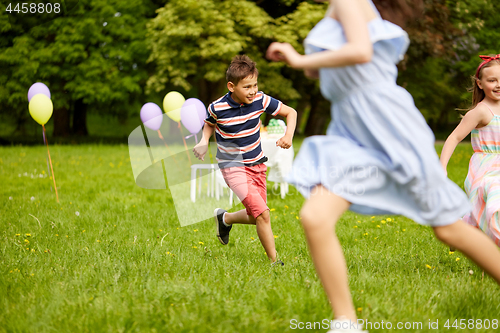 Image of happy kids playing tag game at birthday party