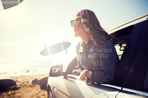 Image of happy teenage girl or young woman in car