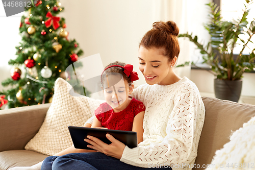 Image of mother and daughter with tablet pc on christmas