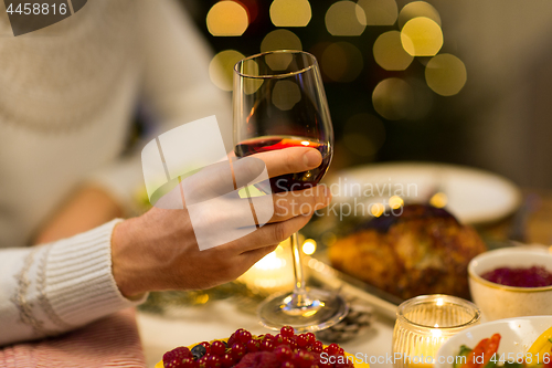 Image of close up of man drinking red wine on christmas