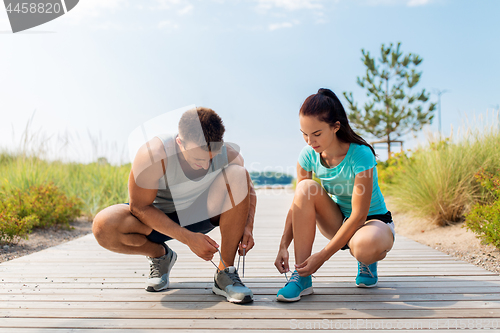 Image of couple of joggers tying sneakers shoelaces