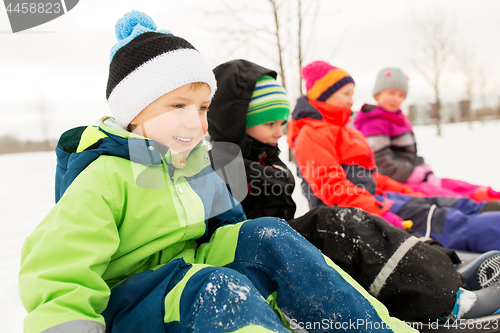 Image of happy little kids riding sleds in winter