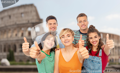 Image of happy friends showing thumbs up over coliseum