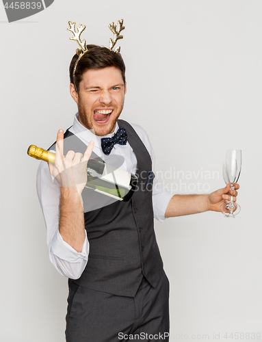 Image of man with bottle of champagne at christmas party