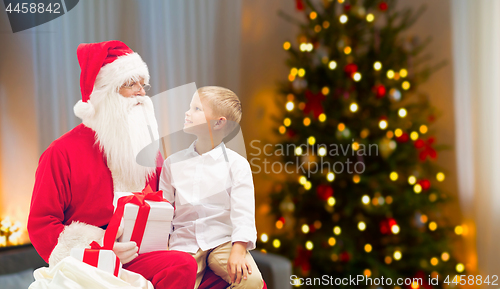 Image of boy and santa with christmas gifts at home