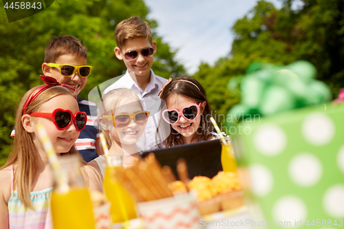 Image of happy kids with tablet pc on birthday party