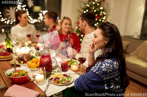 Image of woman calling on smartphone at christmas dinner