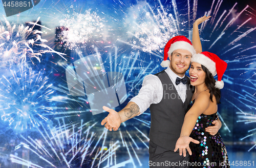 Image of happy couple at christmas party over firework