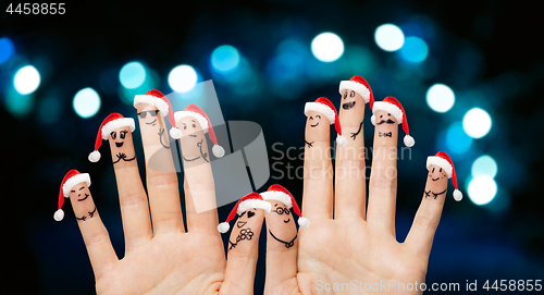 Image of close up of ten fingers in santa hats over lights