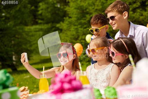 Image of happy kids taking selfie on birthday party