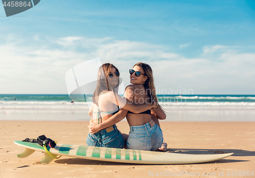 Image of Two surfer girls at the beach