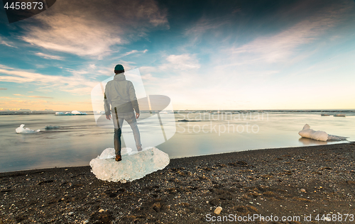 Image of Man standing over a block of Ice