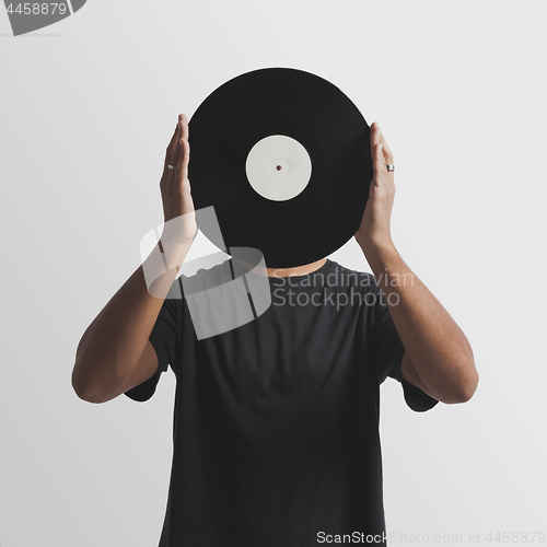 Image of DJ holding a vinyl disk