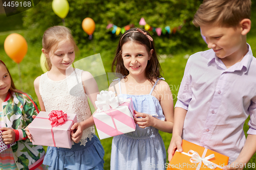 Image of happy kids with gifts on birthday party in summer