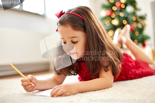 Image of little girl writing christmas wish list at home