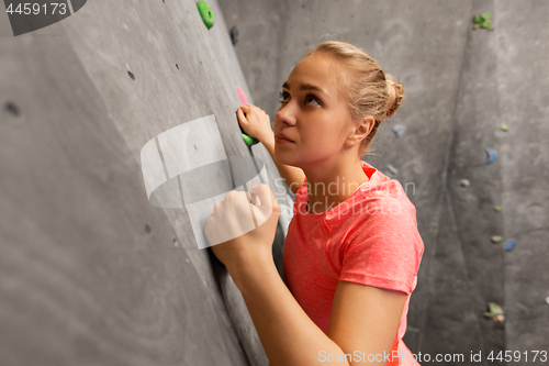 Image of young woman exercising at indoor climbing gym