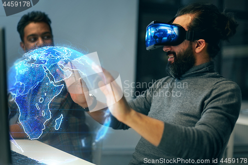 Image of man in vr headset with earth hologram at office