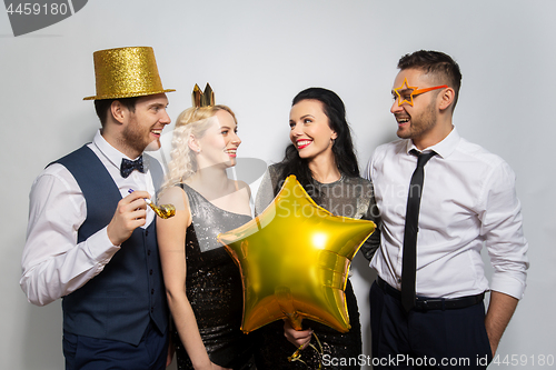 Image of happy friends with golden party props posing