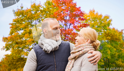 Image of smiling couple leaves in autumn park