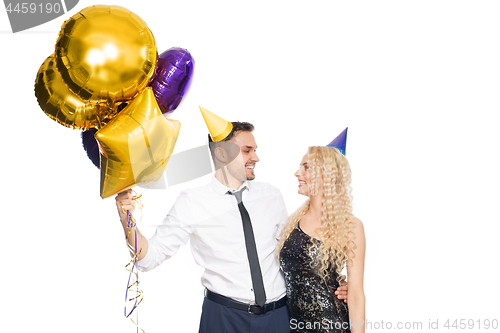 Image of happy couple with party caps and balloons