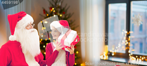 Image of girl and santa with christmas gifts at home