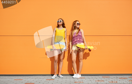 Image of teenage girls with short skateboards in city